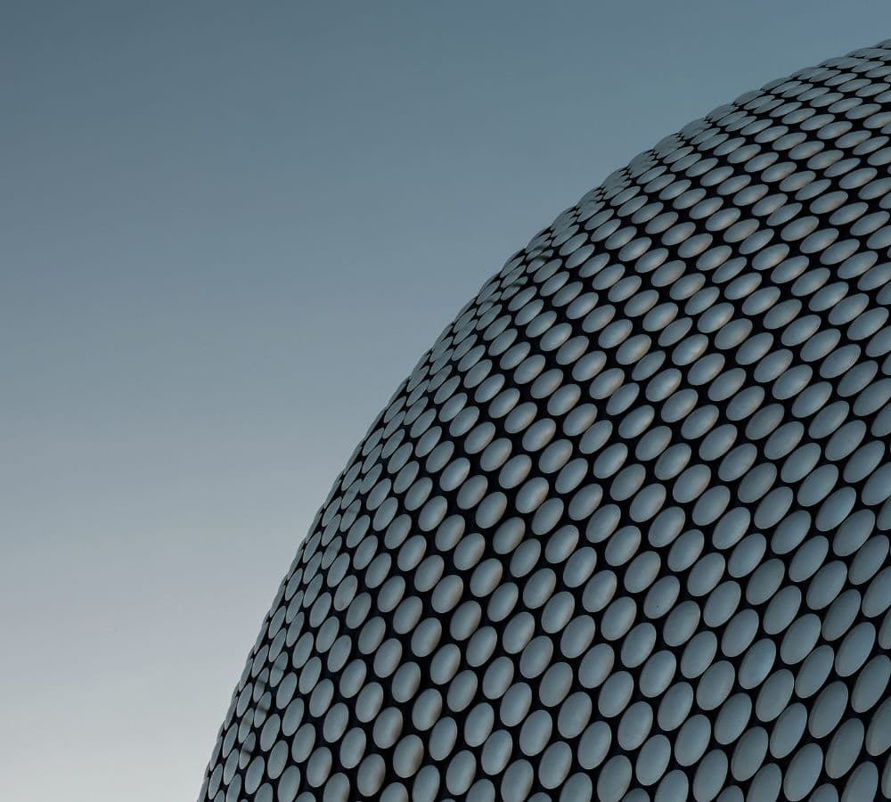 Dramatic upward-angle architectural photo of modern institutional buildings - glass facades and geometric structural elements shot from below against sky, establishing strong institutional presence for Northflow's Nordic and European operational context
