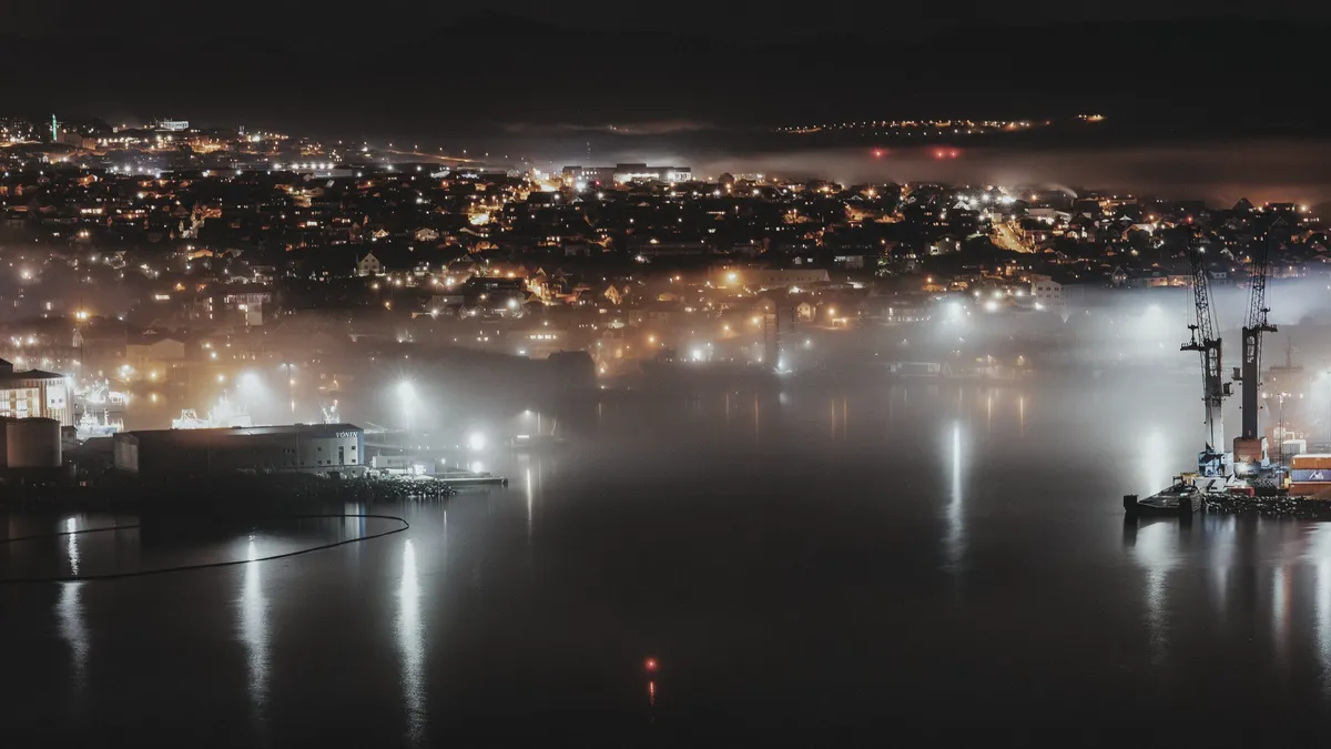 An industrial site at blue hour, lit by many small lights