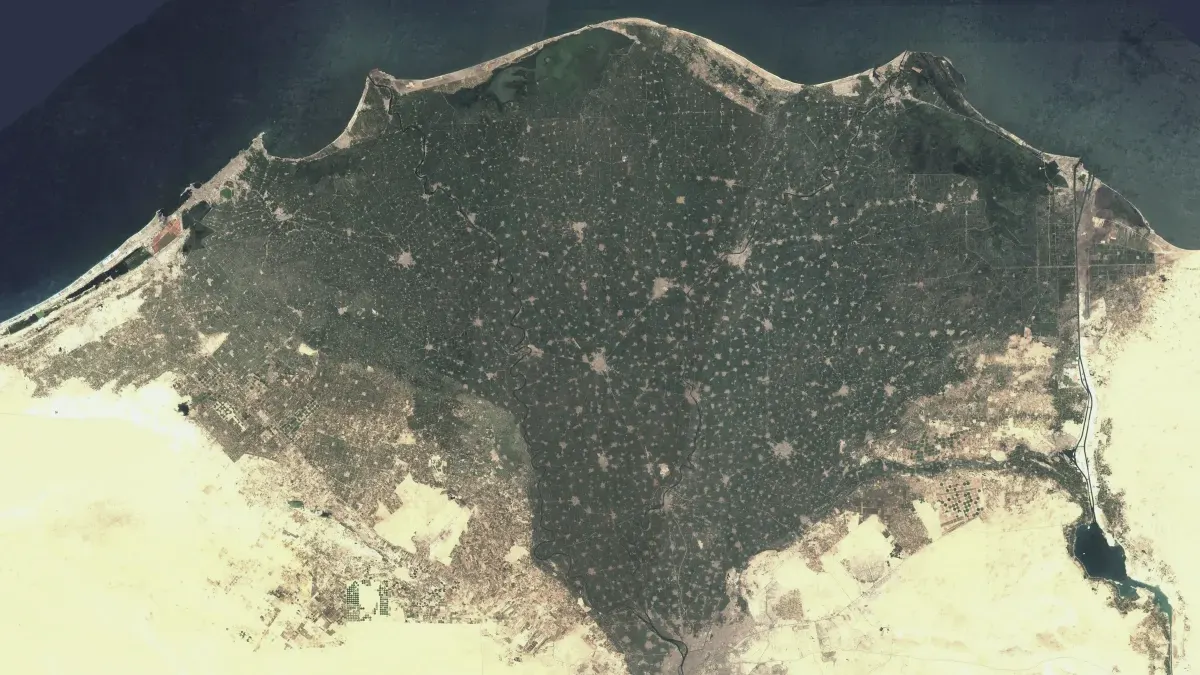 The Nile Delta seen from orbit, green fields fanning out into the desert